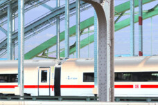 Fotografie von Hilmar Sundermann in surrealer Bearbeitung mit hellen, pastellartigen Farben. ICE-Zug der Deutschen Bahn auf einer Brücke mit Stahlbögen und -streben.