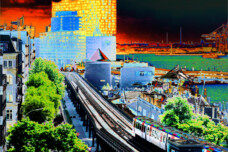 Fotografie von Hilmar Sundermann in surrealer Bearbeitung mit kräftigen Farben. Blick zur Hamburger Elbphilharmonie entlang einer Hochbahnstrecke mit U-Bahn-Zug. Am Bildrand Wasser und Hafenanlagen. Gelb leuchtende Elphi an giftgrüner Elbe vor düsterem schwarzem und rotem Himmel.