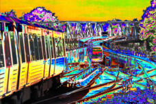 Fotografie von Hilmar Sundermann in surrealer Bearbeitung mit leuchtenden Gelb- und Türkistönen. Zwei U-Bahn-Züge auf geschwungenen Gleisen vor einer Stahlbrücke.