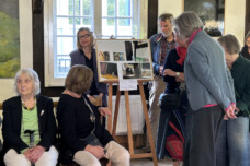 Besucherinnen und Besucher betrachten Aufnahmen.